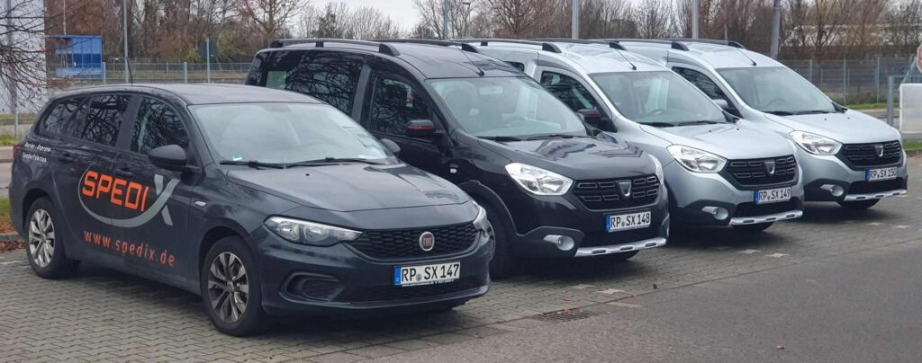 Die Spedix Expressfahrzeuge und Kurierwagen mit Firmenlogo nebeneinander aufgereiht im Raum Speyer.